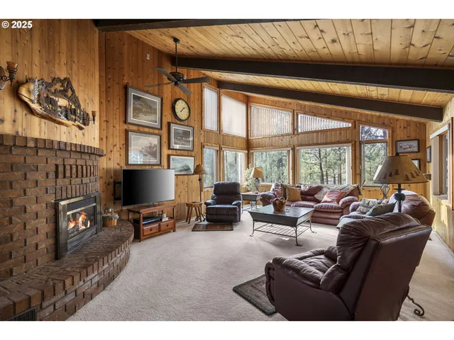 a living room with furniture a flat screen tv and a floor to ceiling window