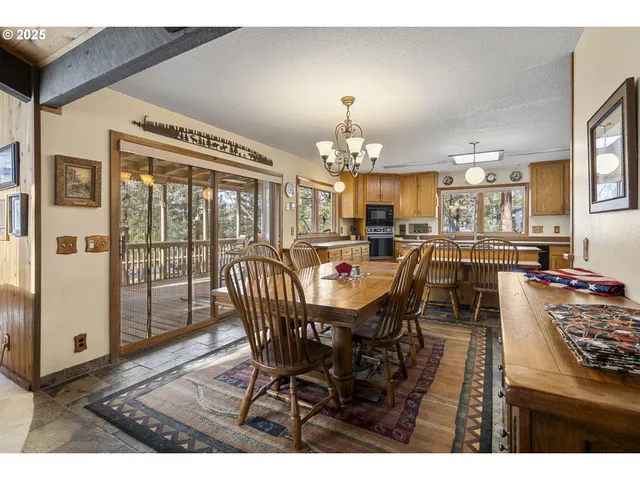 a dining room with furniture a chandelier and wooden floor