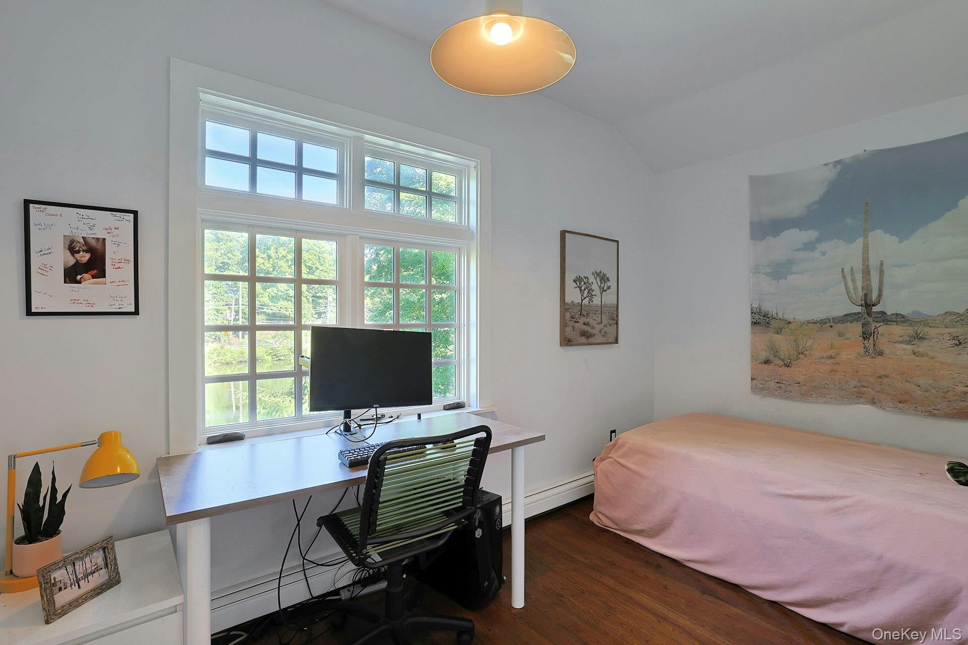 65 Douglas Road Chappaqua, NY 10514 - Photo 28 of 41 A comfortable third bedroom with a beautiful view of the pond offers a peaceful and inviting space, filled with the natural charm of the property’s waterfront setting.