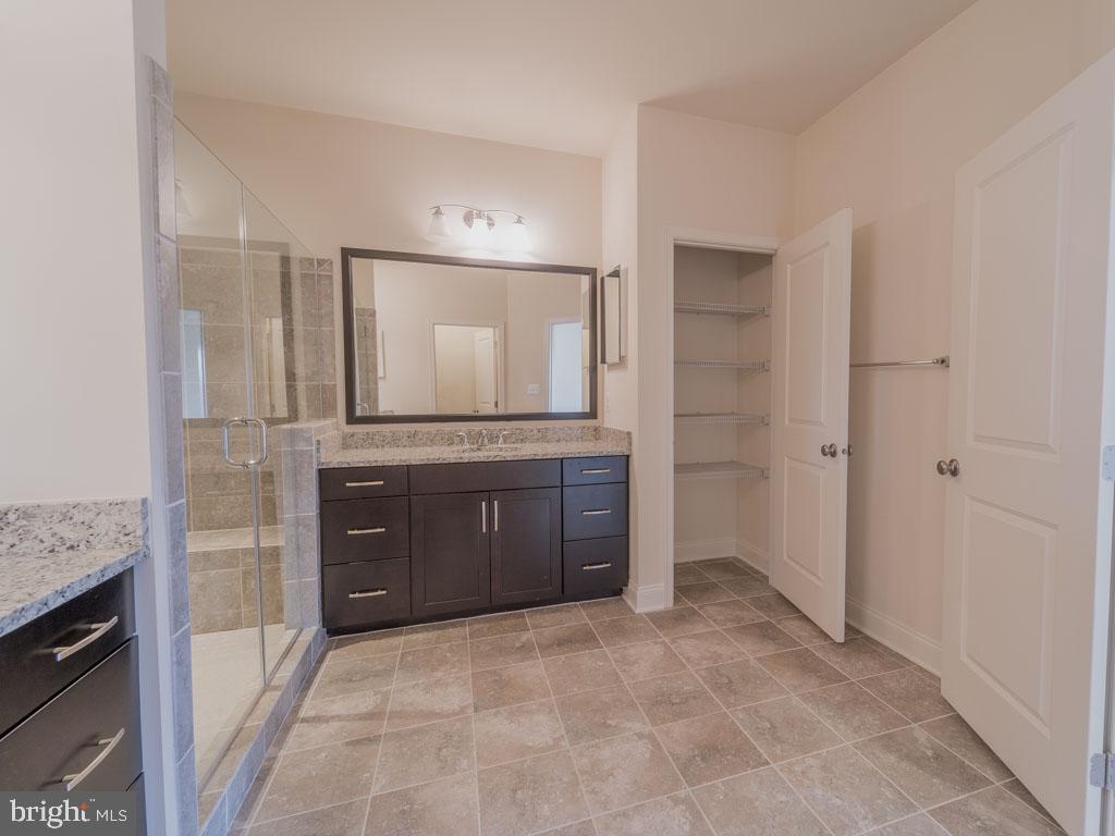 22595 Windsor Locks Square Ashburn, VA 20148 - Photo 42 of 56 a spacious bathroom with a granite countertop sink and a mirror