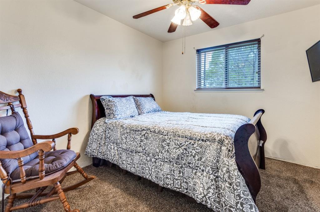 2413 Cheyenne Street Irving, TX 75062 - Photo 14 of 19 a bedroom with a bed and a chandelier