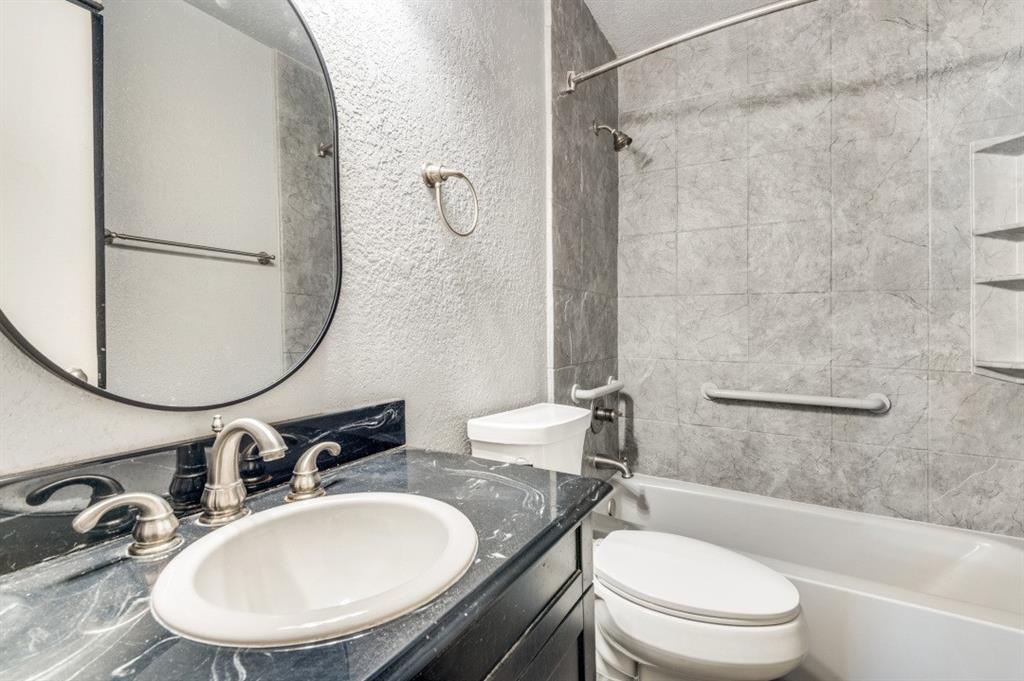 2413 Cheyenne Street Irving, TX 75062 - Photo 16 of 19 a bathroom with a granite countertop sink toilet a mirror and vanity
