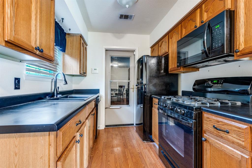2413 Cheyenne Street Irving, TX 75062 - Photo 9 of 19 a kitchen with stainless steel appliances granite countertop a sink stove and refrigerator