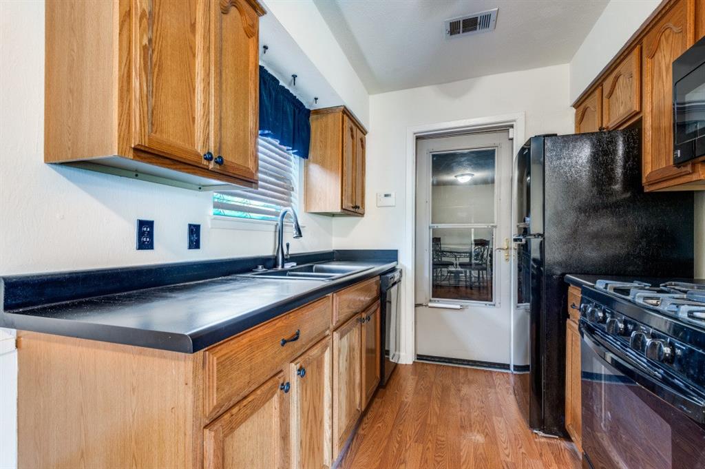 2413 Cheyenne Street Irving, TX 75062 - Photo 10 of 19 a kitchen with stainless steel appliances granite countertop a sink stove and refrigerator