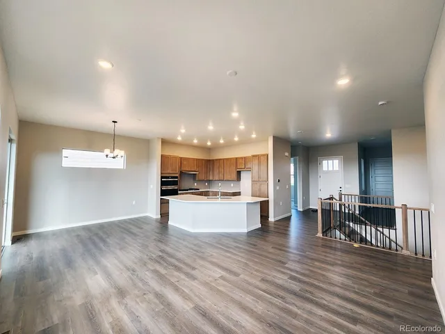 a view of kitchen with kitchen island wooden floor center island and stainless steel appliances