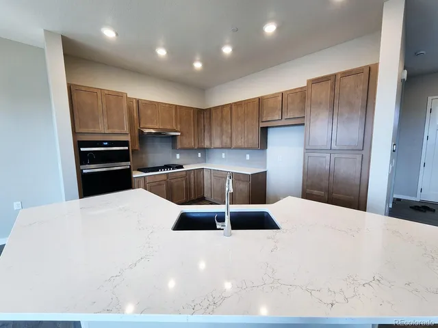 a kitchen with granite countertop a refrigerator and a sink