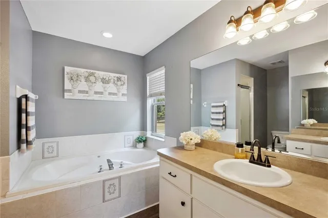 a en suite bathroom with a double vanity sink and a mirror