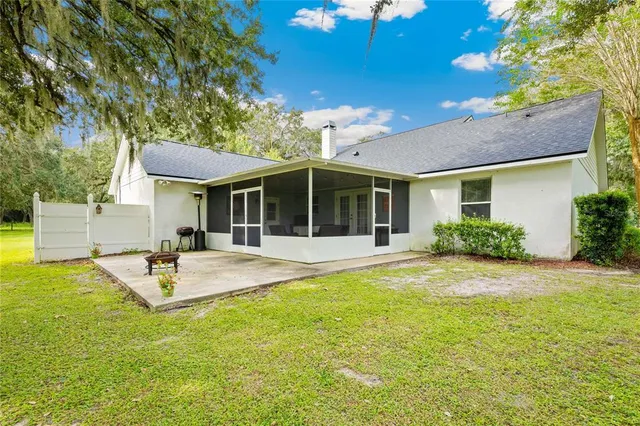 an aerial view of residential houses with outdoor space and trees all around