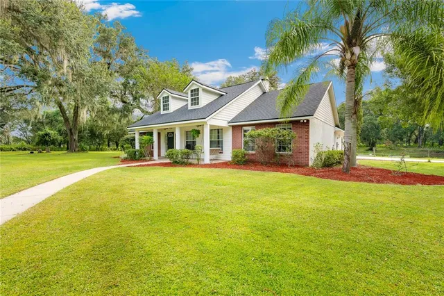 a front view of a house with a garden and swimming pool