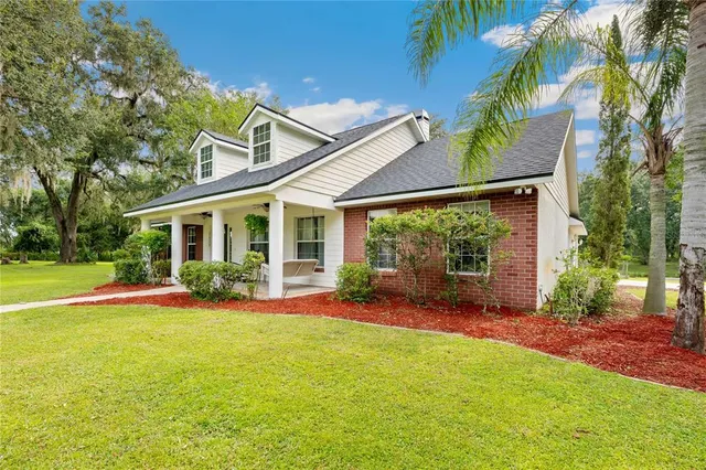 a view of a house with a yard and sitting area