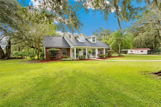 a front view of house with swimming pool and green space