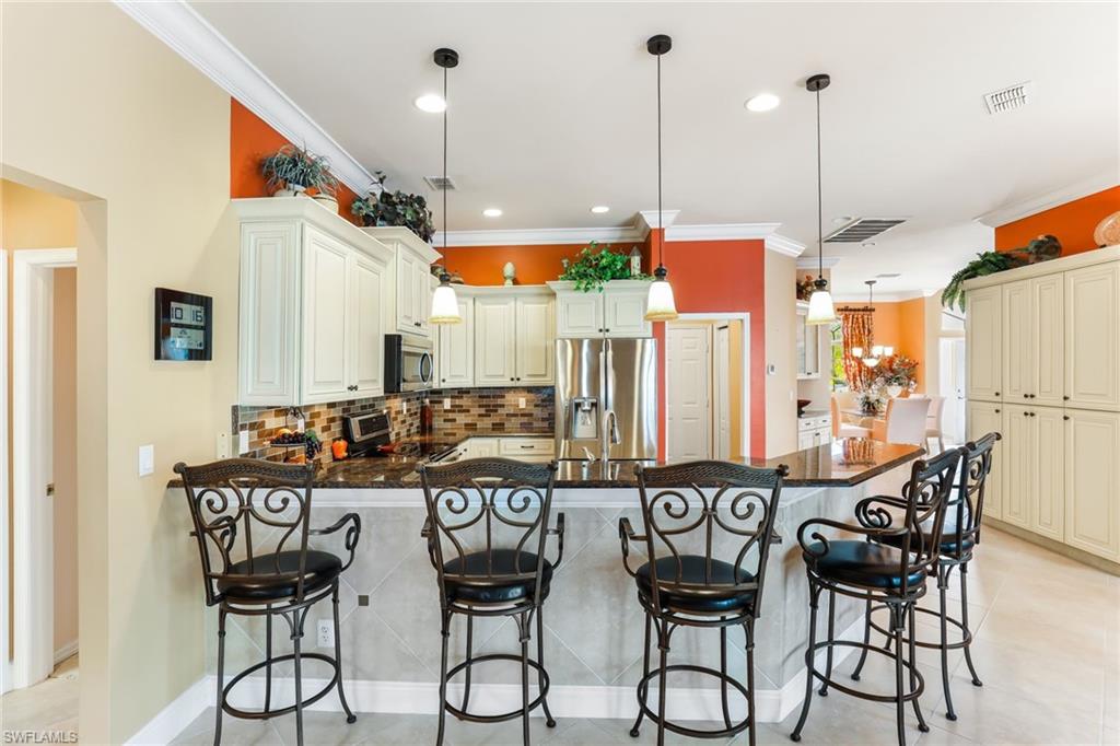 8906 Lely Island Circle Naples, FL 34113 - Photo 14 of 34 a view of a dining table chairs and chandelier