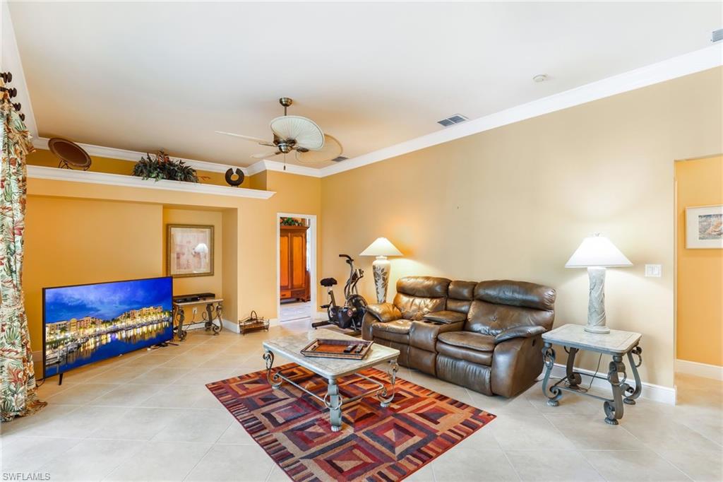 8906 Lely Island Circle Naples, FL 34113 - Photo 17 of 34 a living room with furniture and a lamp