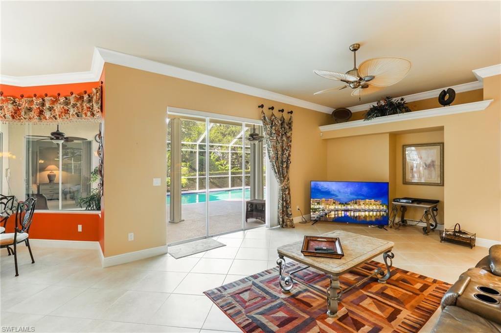 8906 Lely Island Circle Naples, FL 34113 - Photo 18 of 34 a living room with furniture a flat screen tv and a window