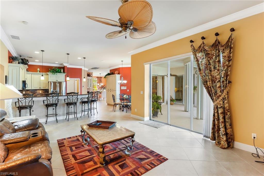 8906 Lely Island Circle Naples, FL 34113 - Photo 19 of 34 a living room with lots of furniture and a chandelier