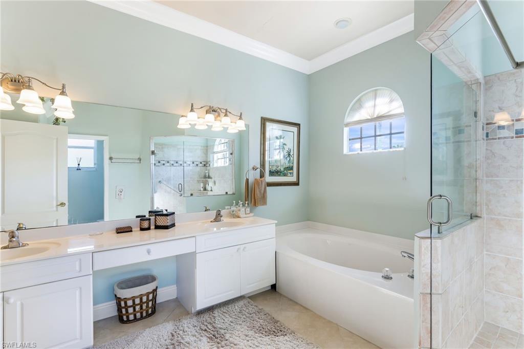 8906 Lely Island Circle Naples, FL 34113 - Photo 21 of 34 a bathroom with a bathtub a sink and a mirror