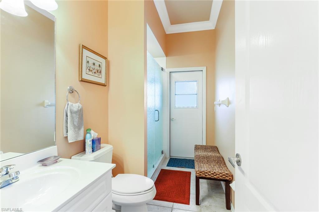 8906 Lely Island Circle Naples, FL 34113 - Photo 23 of 34 a bathroom with a granite countertop toilet sink and mirror