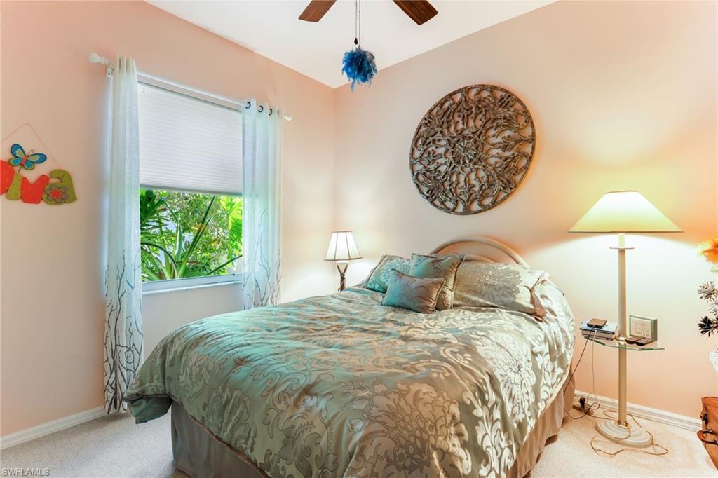 8906 Lely Island Circle Naples, FL 34113 - Photo 24 of 34 a bedroom with a bed and a lamp