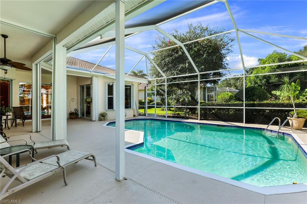 8906 Lely Island Circle Naples, FL 34113 - Photo 28 of 34 a view of a swimming pool with a lounge chairs