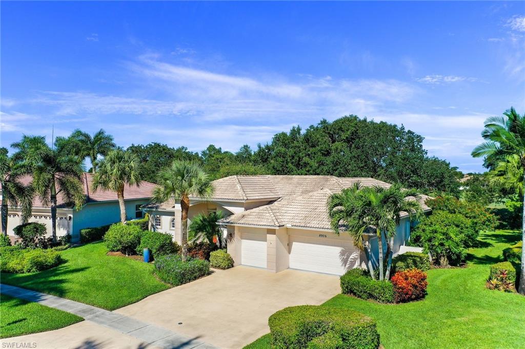 8906 Lely Island Circle Naples, FL 34113 - Photo 3 of 34 a view of a garden with a building in the background