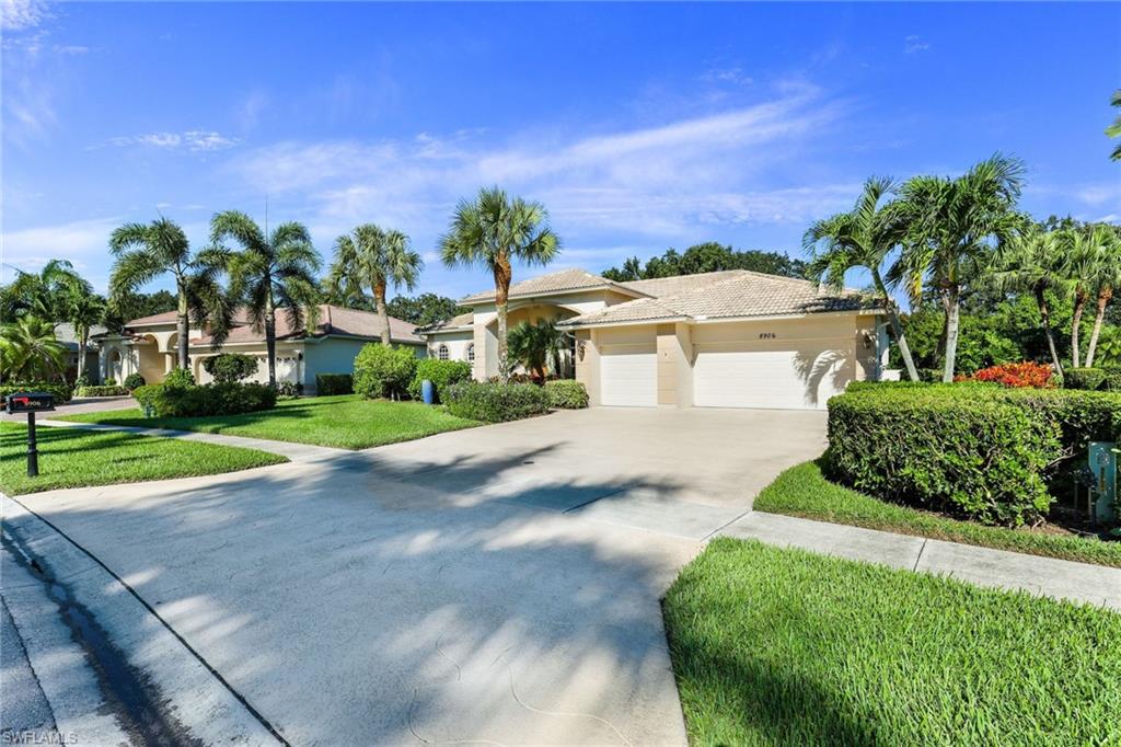 8906 Lely Island Circle Naples, FL 34113 - Photo 4 of 34 a front view of a house with a yard and potted plants