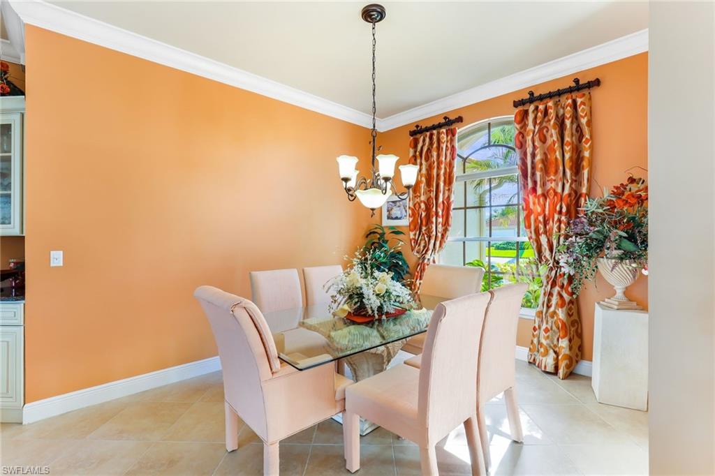8906 Lely Island Circle Naples, FL 34113 - Photo 6 of 34 a dining room with furniture potted plants and wooden floor