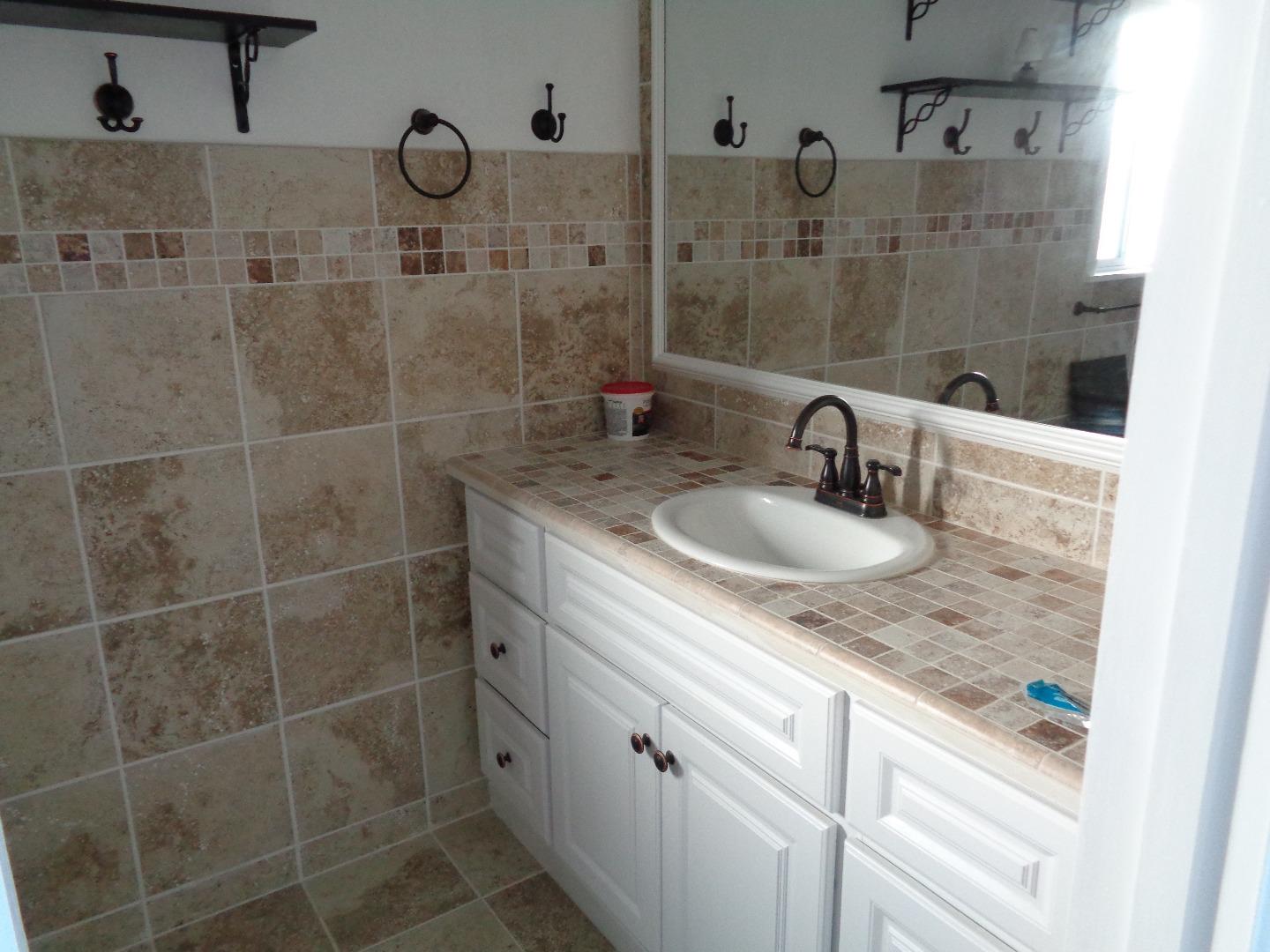 26 Miller Road Watsonville, CA 95076 - Photo 7 of 10 a bathroom with a granite countertop sink a mirror and shower