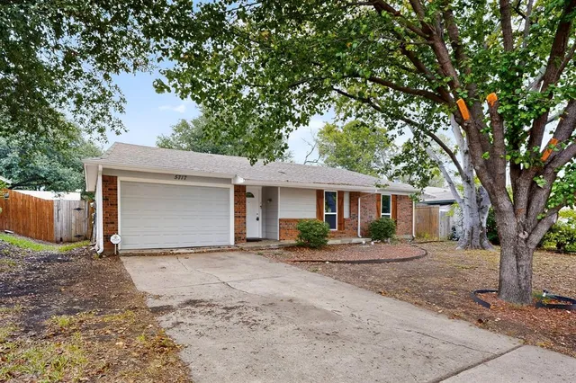 a front view of a house with a yard and trees