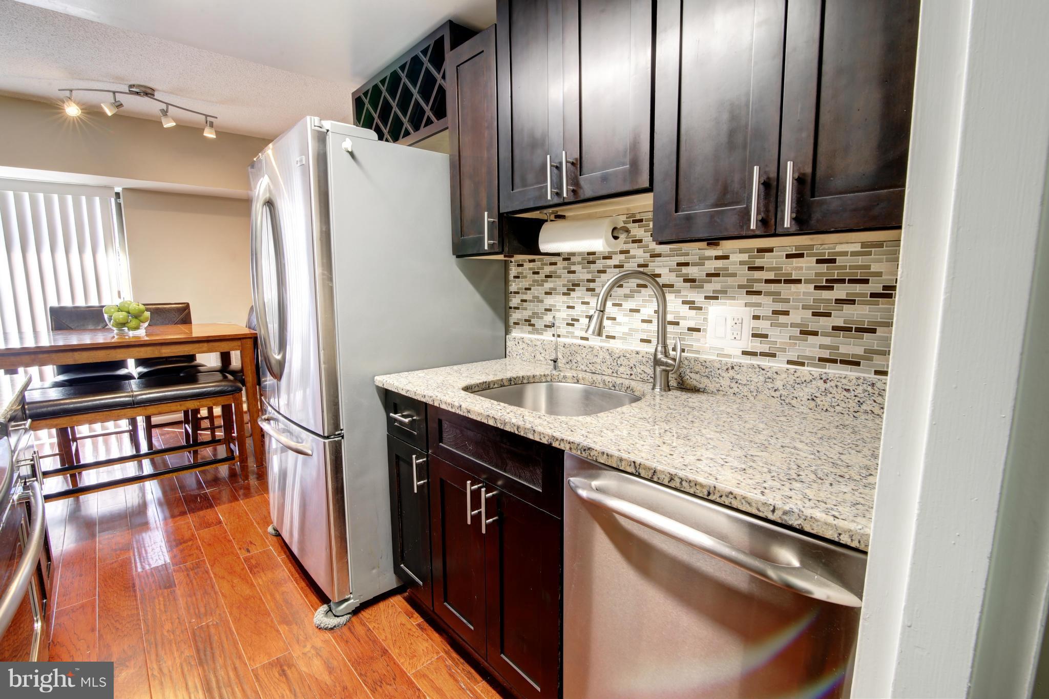 11627 Stoneview Square, Unit 11C Reston, VA 20191 - Photo 3 of 19 a kitchen with stainless steel appliances granite countertop a sink stove and refrigerator