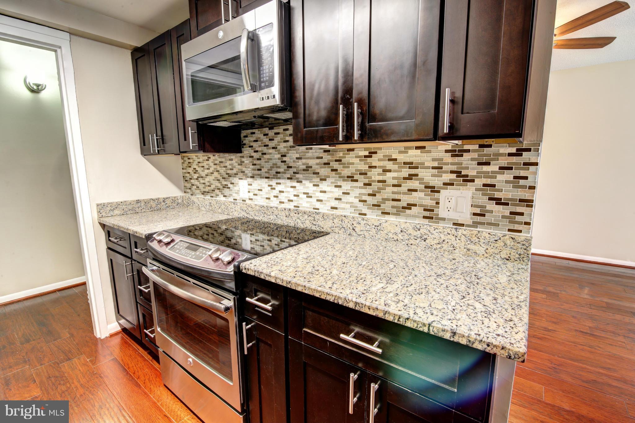 11627 Stoneview Square, Unit 11C Reston, VA 20191 - Photo 4 of 19 a view of a kitchen with granite countertop a sink and a stove
