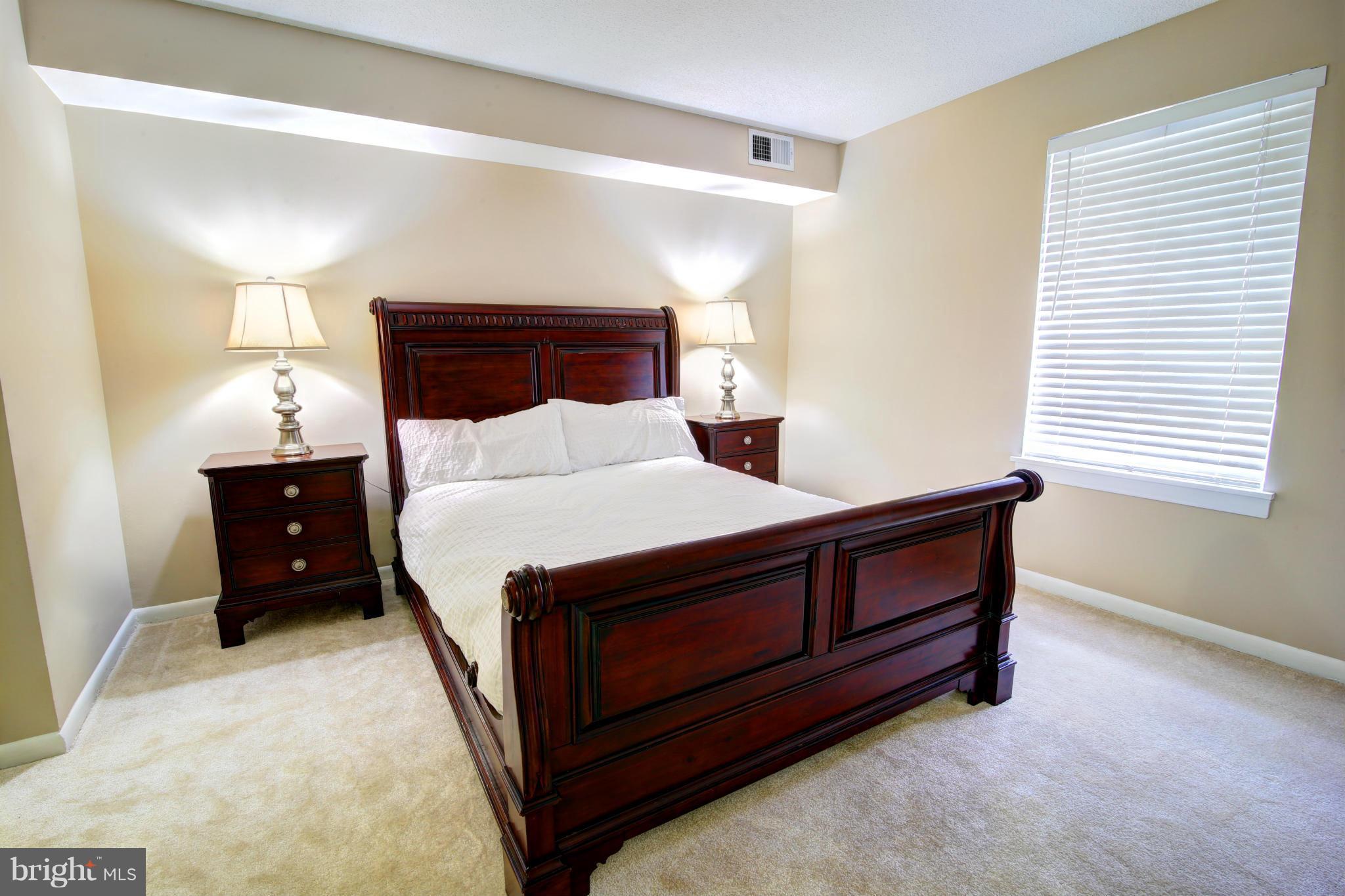 11627 Stoneview Square, Unit 11C Reston, VA 20191 - Photo 8 of 19 a bed sitting in a bedroom next to a window