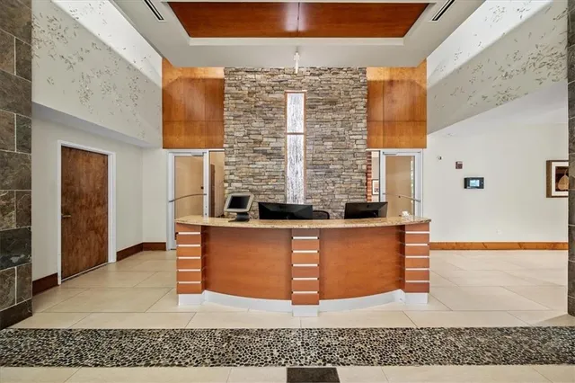 a view of kitchen with stainless steel appliances granite countertop wooden cabinets and a fireplace