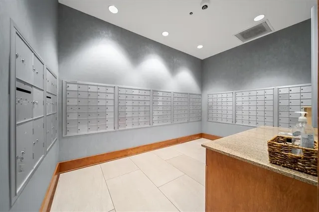 a kitchen with stainless steel appliances a refrigerator a sink and white cabinets