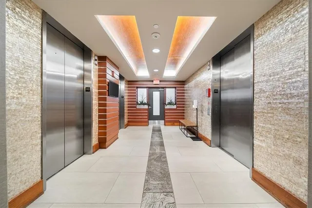 a hallway with seating area and stainless steel appliances