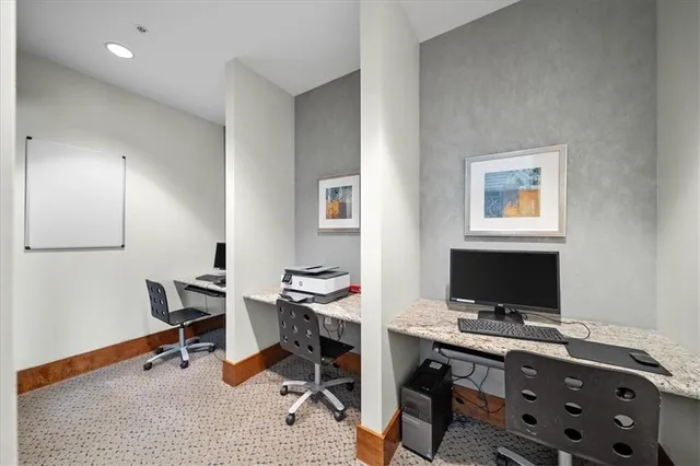 a view of a workspace with furniture and a window