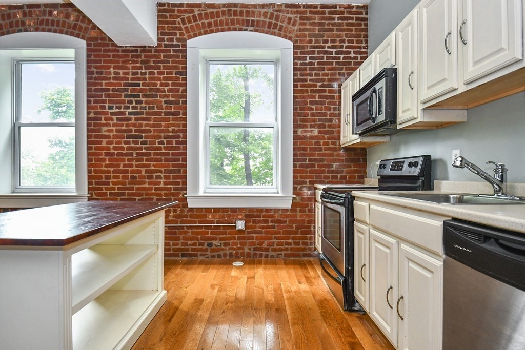 32 Providence Street, Unit 5 Worcester, MA 01604 - Photo 5 of 24 a kitchen with stainless steel appliances granite countertop a stove a sink and a white wooden cabinets