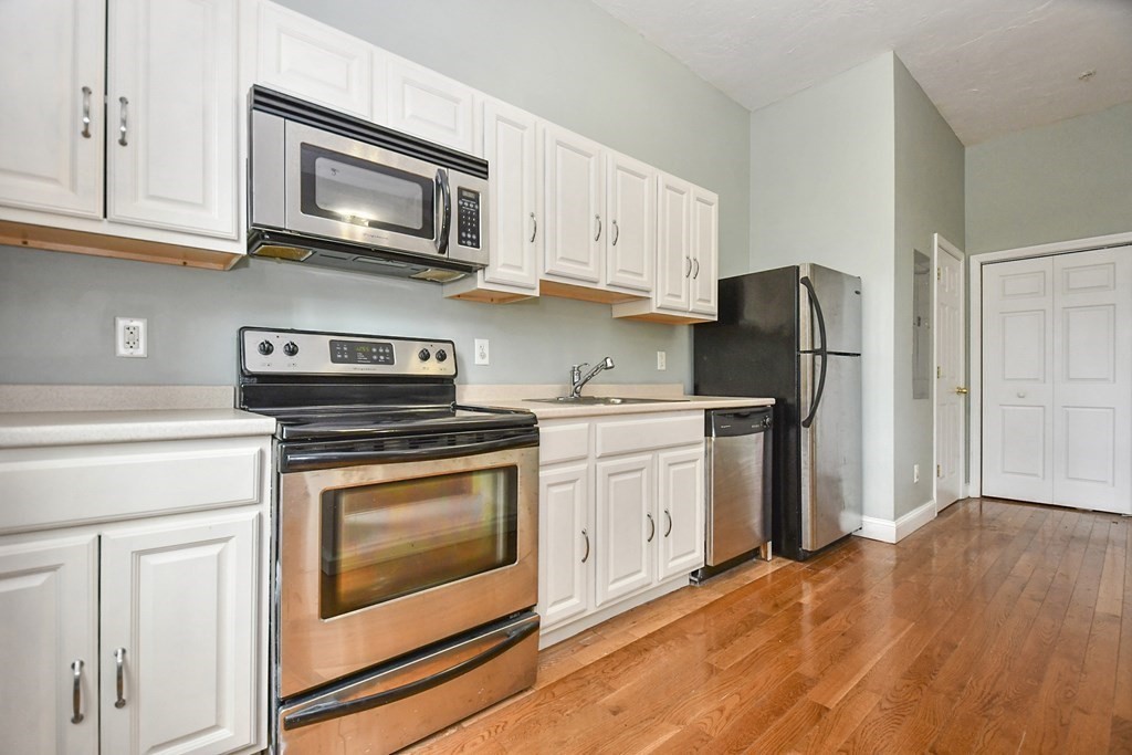 32 Providence Street, Unit 5 Worcester, MA 01604 - Photo 6 of 24 a kitchen with stainless steel appliances granite countertop a refrigerator stove and microwave