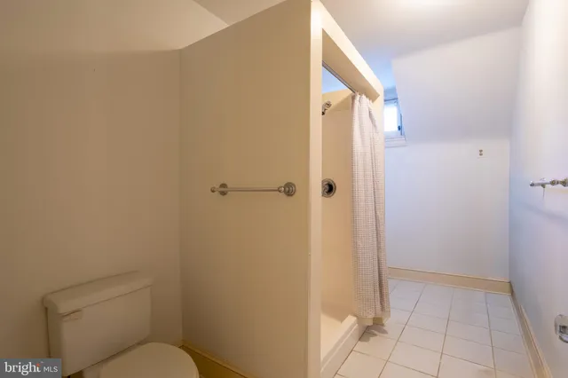 a bathroom with a granite countertop toilet and a shower