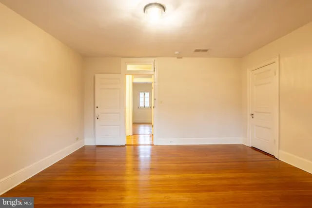 a view of an empty room and wooden floor