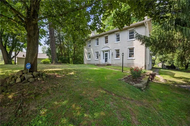 a front view of a house with a yard and trees