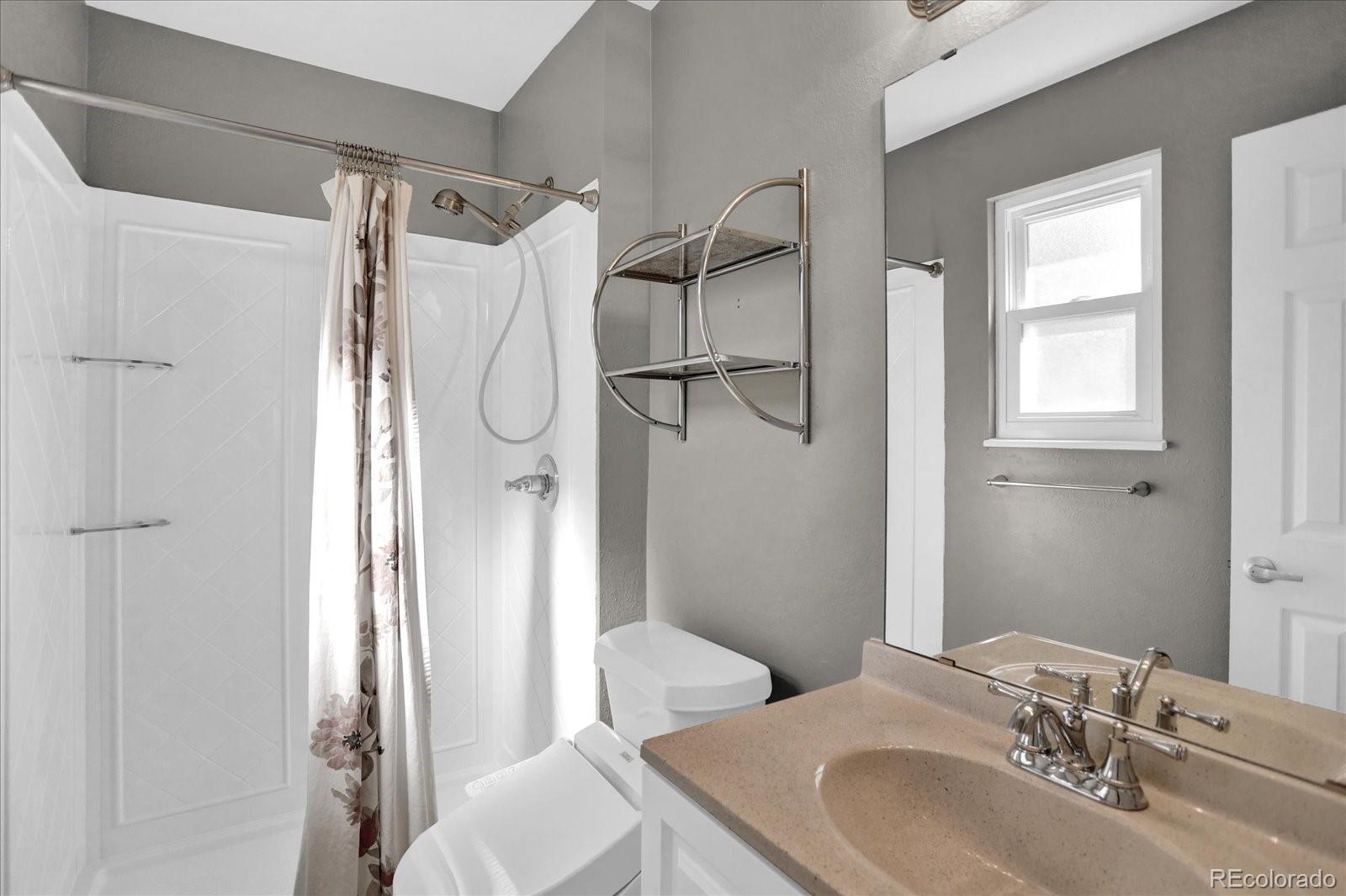 3754 South Walden Way Aurora, CO 80013 - Photo 15 of 32 a bathroom with a sink toilet and shower