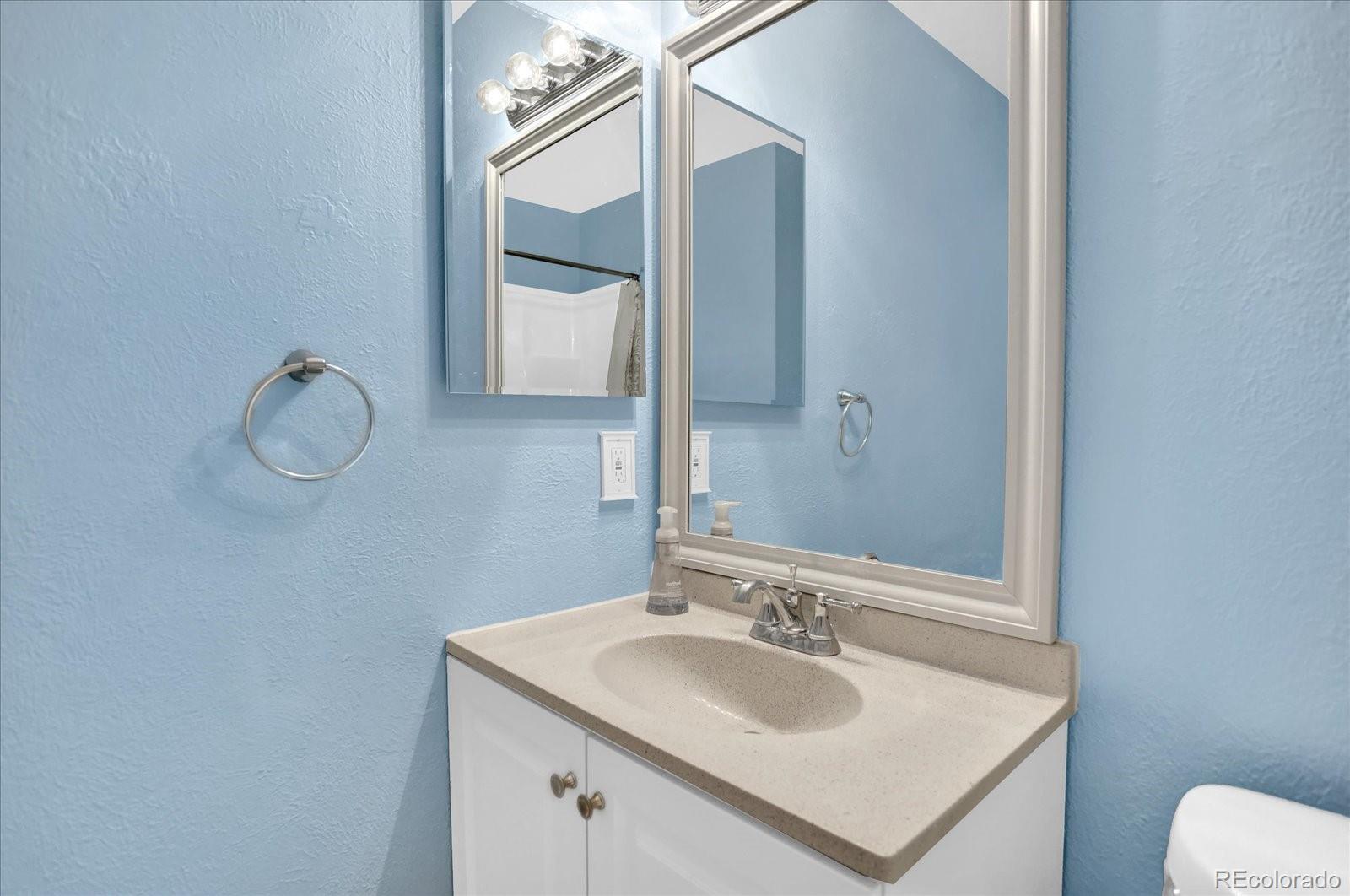 3754 South Walden Way Aurora, CO 80013 - Photo 18 of 32 a bathroom with a sink vanity and a mirror