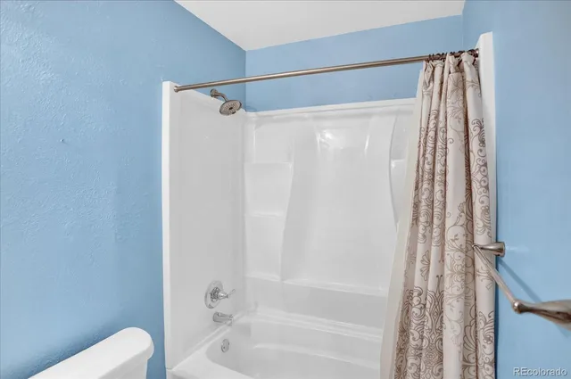 a bathroom with a shower curtain and a toilet