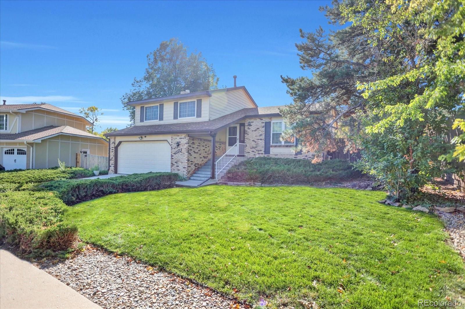 3754 South Walden Way Aurora, CO 80013 - Photo 2 of 32 a front view of a house with garden