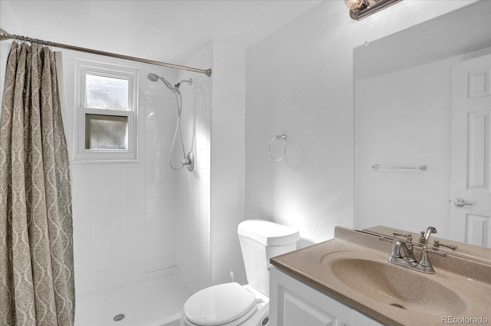 3754 South Walden Way Aurora, CO 80013 - Photo 23 of 32 a bathroom with a granite countertop sink toilet and shower