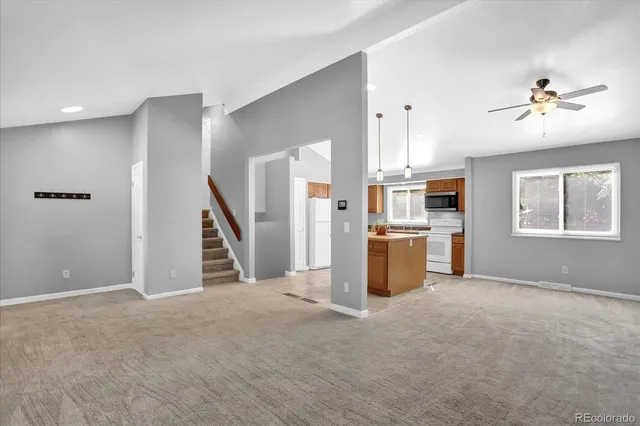 a view of a kitchen with furniture ceiling fan and window