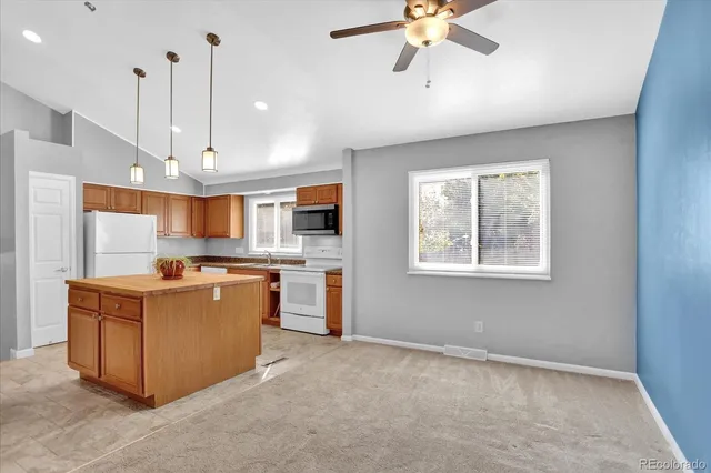 a large kitchen with stainless steel appliances granite countertop a stove and a view of living room