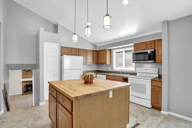 a kitchen that has a sink a microwave oven a stove and a refrigerator