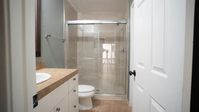 a bathroom with a granite countertop shower a toilet and a sink