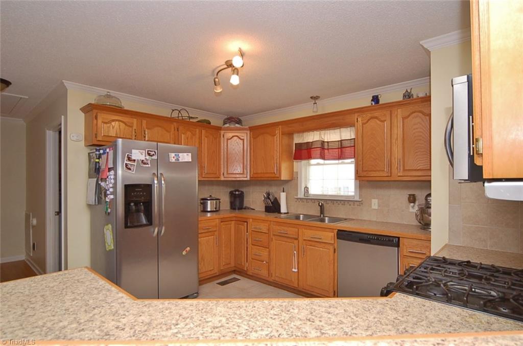 752 Arnold Road Lexington, NC 27295 - Photo 13 of 30 Kitchen with newer stainless appliances and a tile backsplash.
